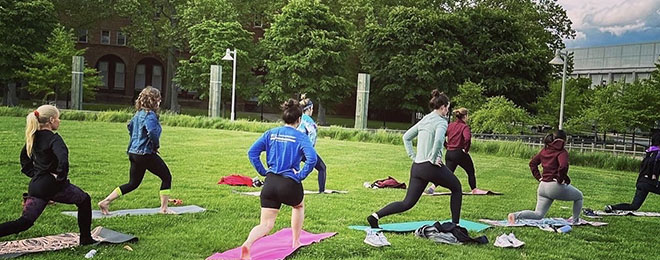Image of people doing yoga in a park.