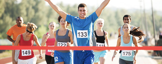 Image of people approaching the finish line at the end of a race.